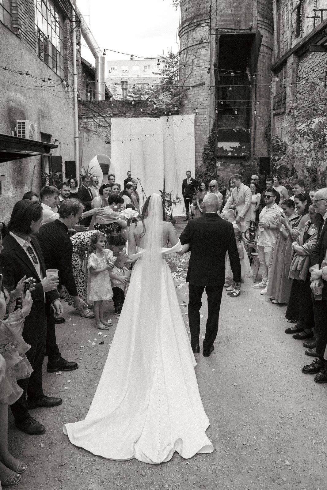 Bride walking down the aisle with her father, seen from behind